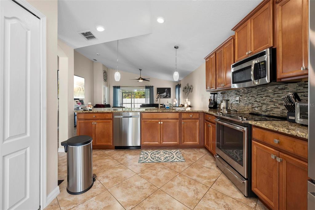 10114 Ives Loop Hudson, FL 34667 - Photo 20 of 49 a kitchen with stainless steel appliances granite countertop a sink a stove a refrigerator cabinets and a window