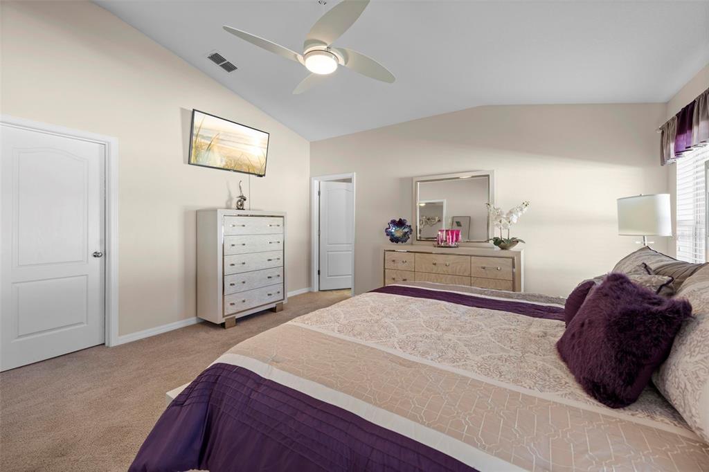 10114 Ives Loop Hudson, FL 34667 - Photo 28 of 49 a bedroom with a bed and a mirror