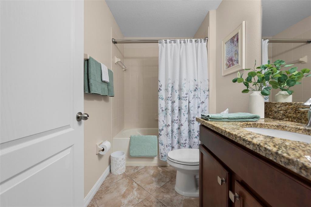 10114 Ives Loop Hudson, FL 34667 - Photo 38 of 49 a bathroom with a granite countertop sink a toilet and shower