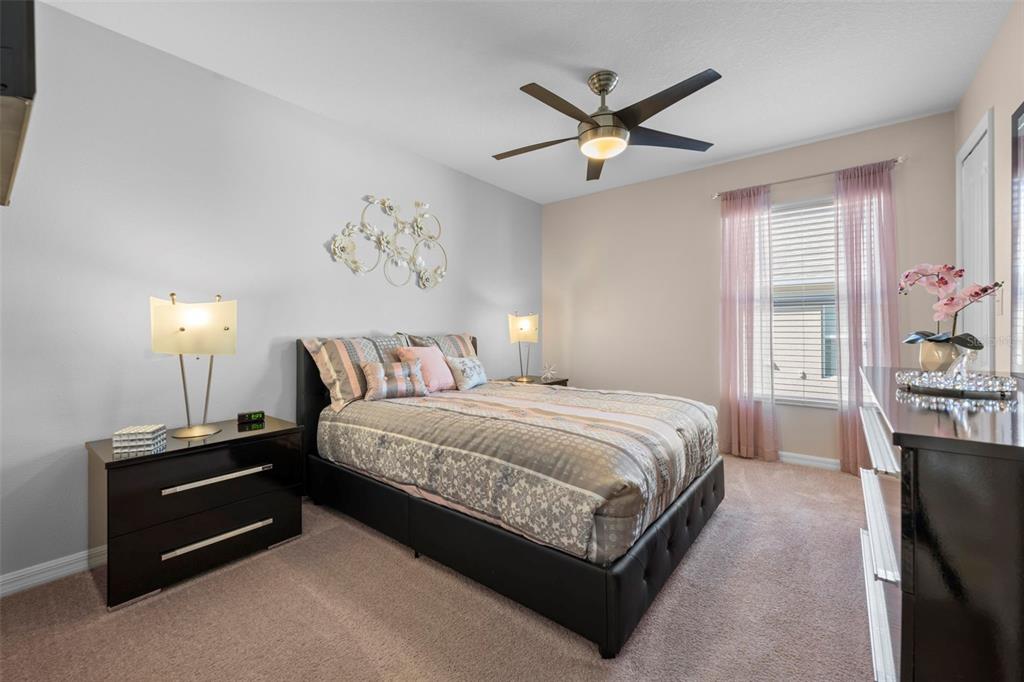 10114 Ives Loop Hudson, FL 34667 - Photo 39 of 49 a bedroom with a bed and a chandelier