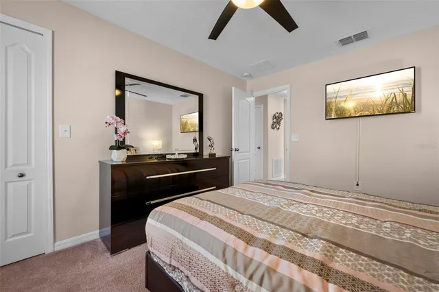 a bedroom with a bed and a flat tv screen on dresser