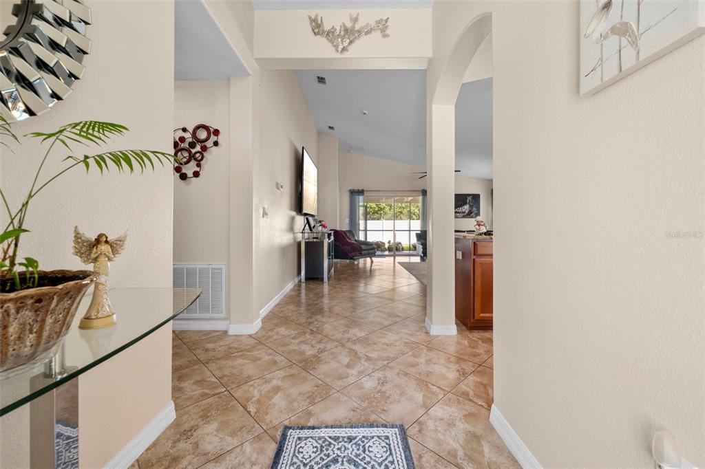 10114 Ives Loop Hudson, FL 34667 - Photo 8 of 49 a hallway with a dining table and chairs