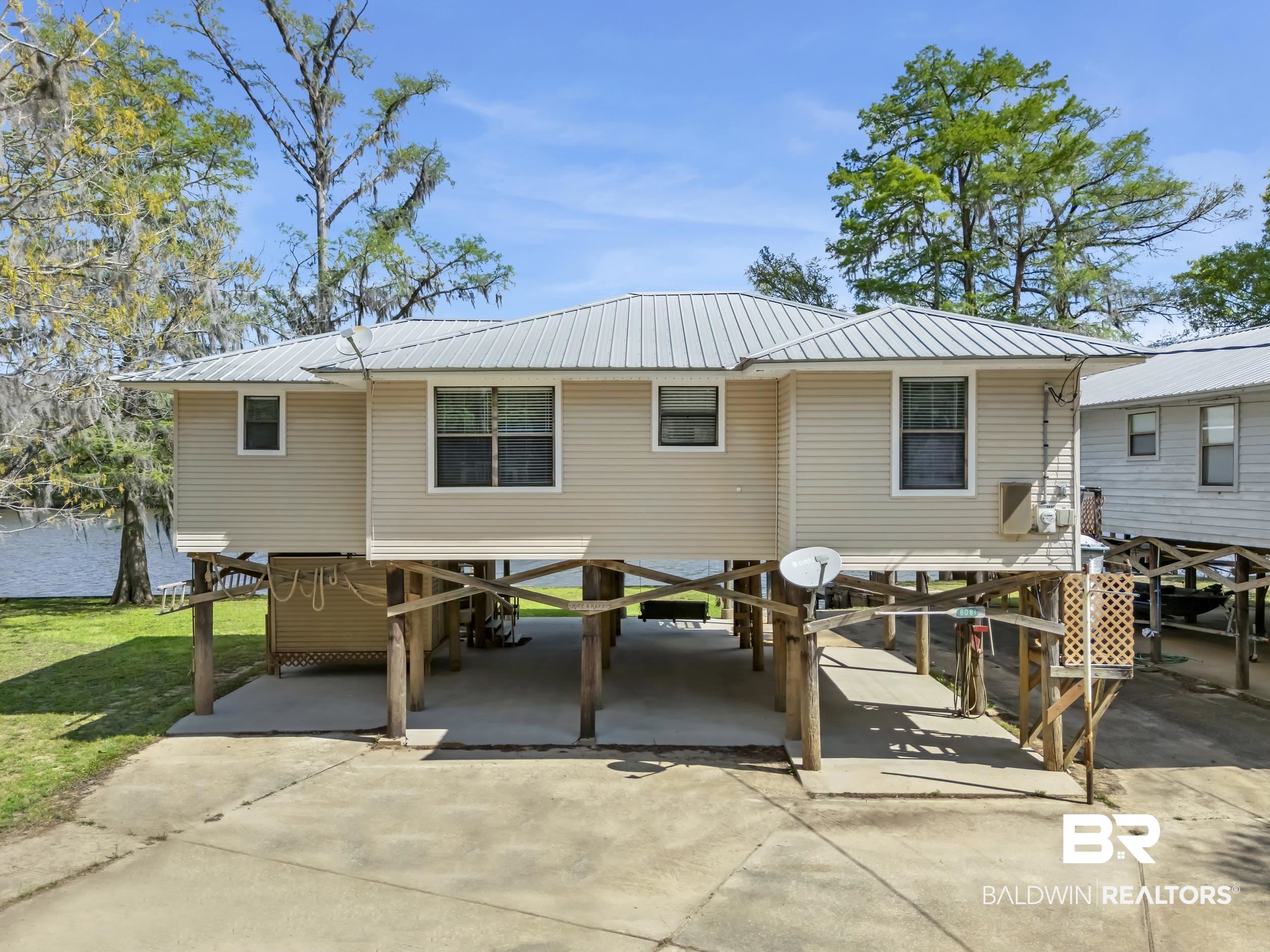 8081 Bryant's Lndg Road Stockton, AL 36579 - Photo 4 of 48 Back of property featuring a carport, a metal roof, concrete driveway, and a patio area