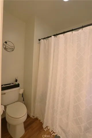 a white toilet sitting next to a shower curtain