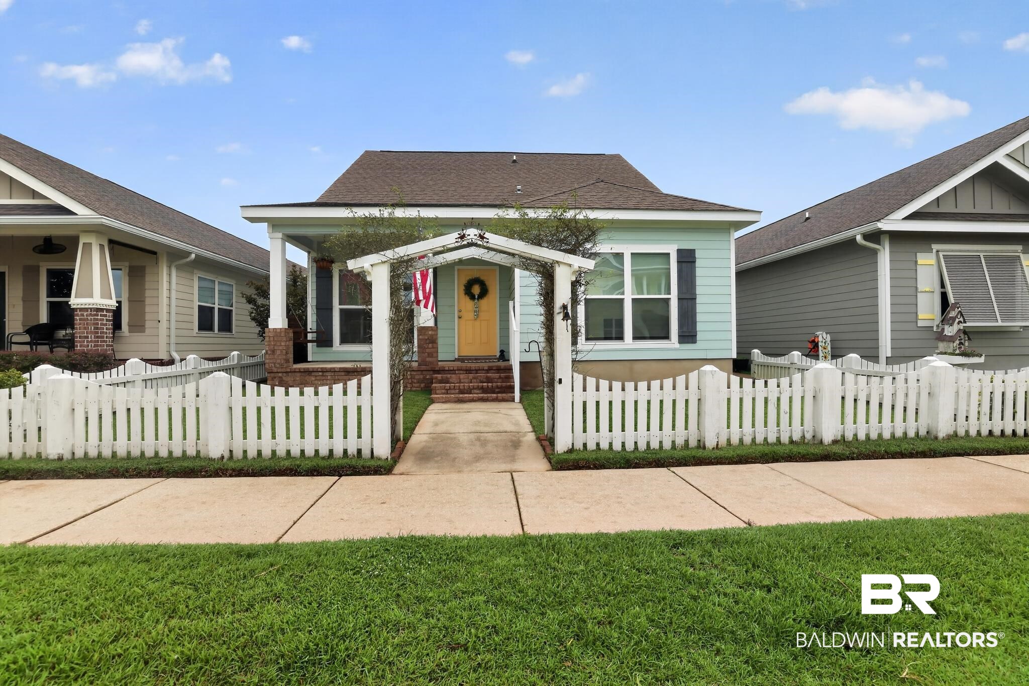 1210 Primrose Lane Foley, AL 36535 - Photo 1 of 33 Light blue exterior with dark shutters, front porch, and a yellow entry door