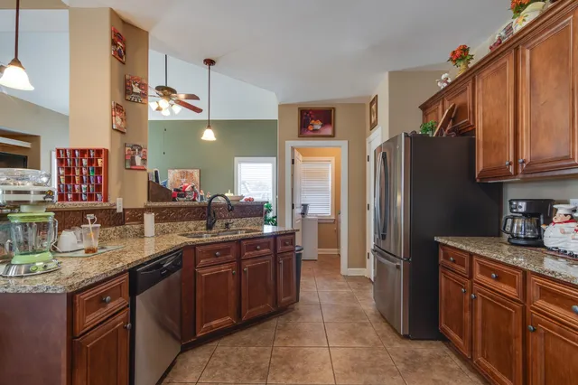 a kitchen with stainless steel appliances granite countertop a sink stove and refrigerator
