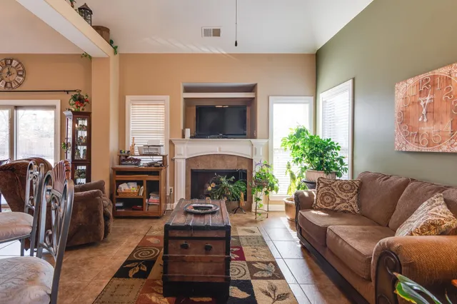a living room with furniture a flat screen tv and a fireplace