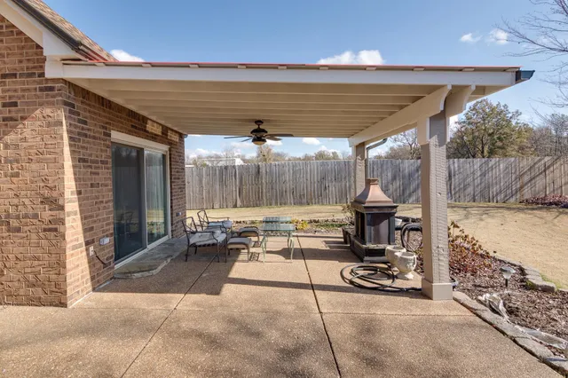 a view of a patio with a table chairs and a barbeque