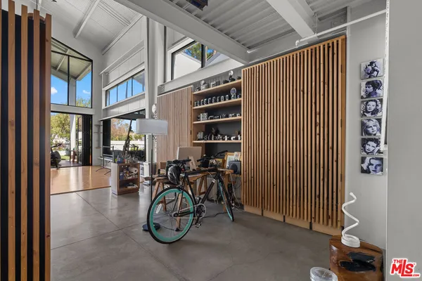 a living room with furniture a floor to ceiling window and stainless steel appliances
