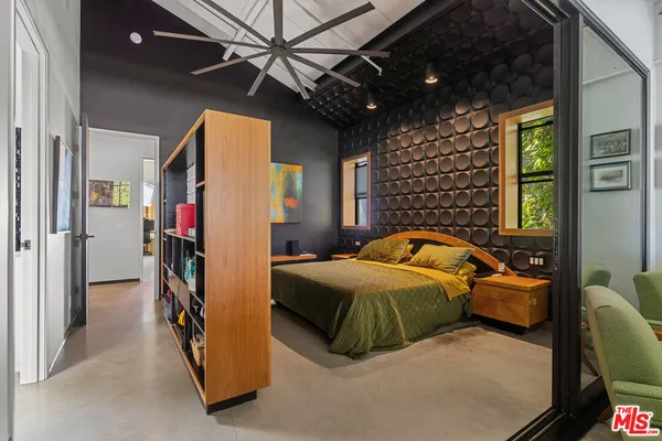 a bedroom with a bed and a flat screen tv