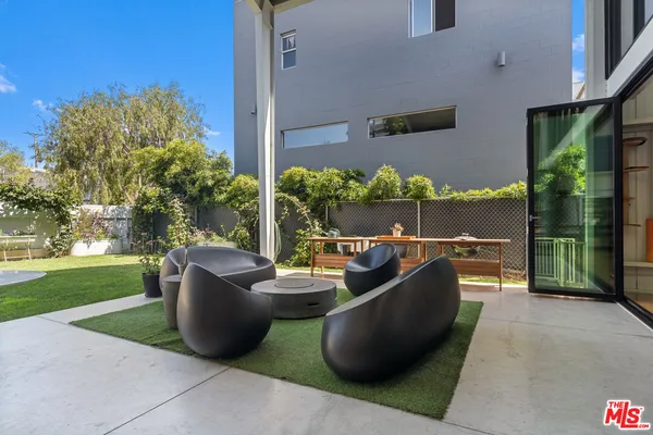 a view of a patio with couches chairs potted plants and a big yard