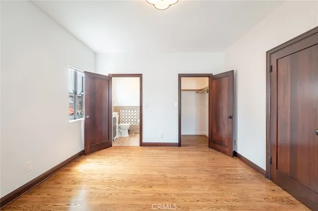 a view of an empty room with closet and a window