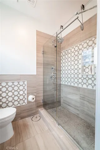 a bathroom with a toilet and a shower