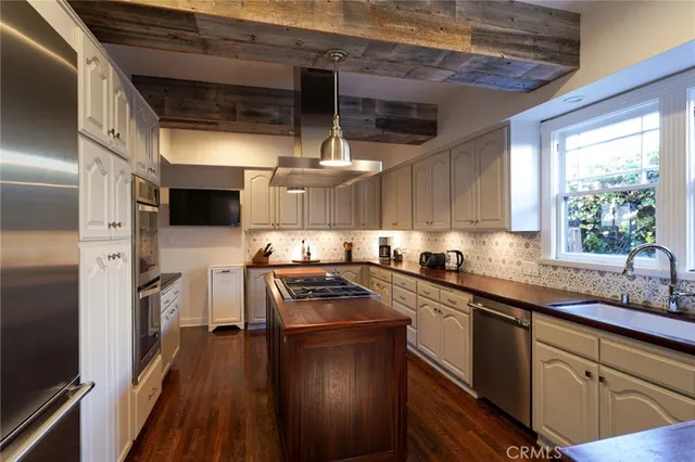 a kitchen with stainless steel appliances granite countertop a sink a stove and a refrigerator