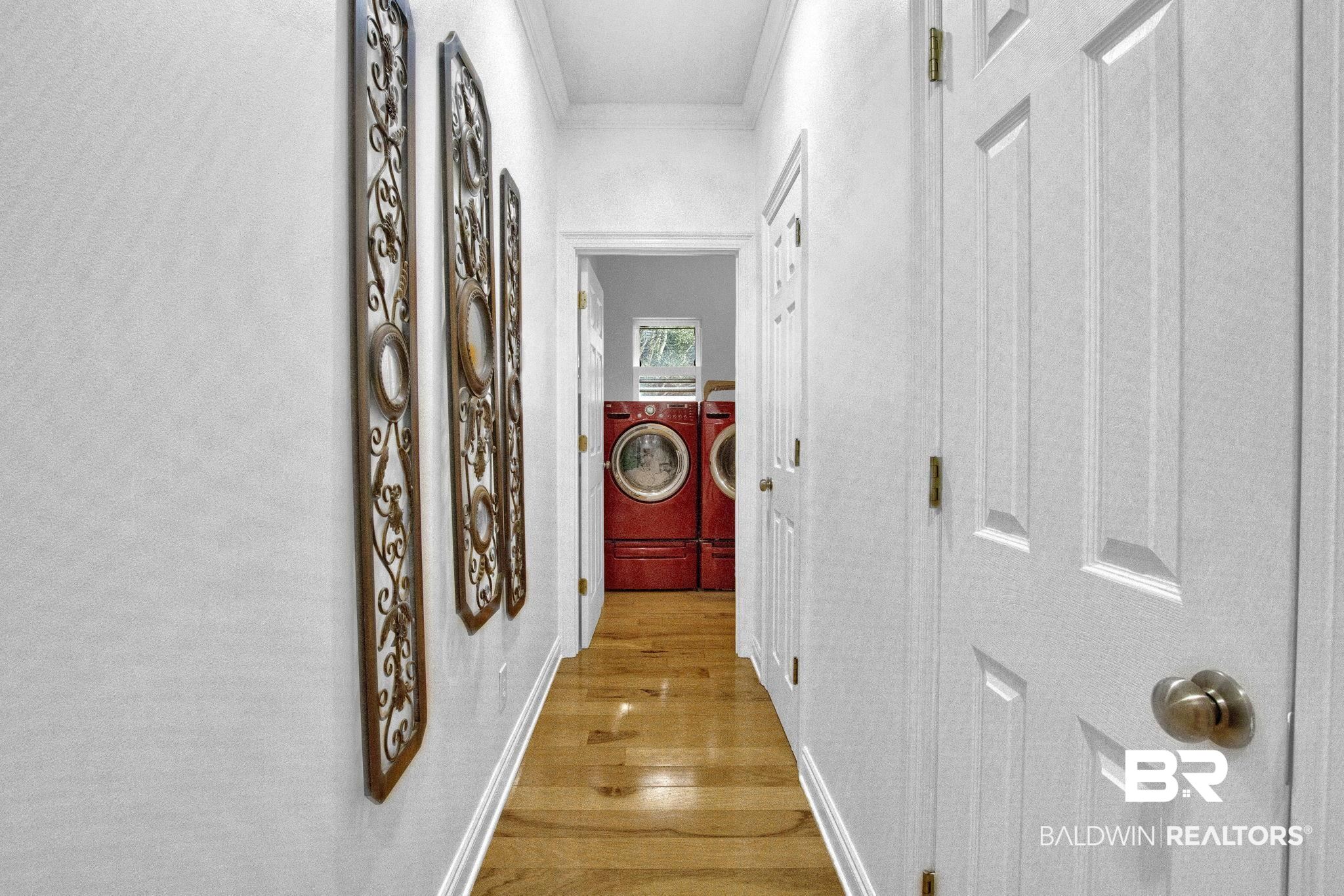9002 Parliament Circle Daphne, AL 36526 - Photo 43 of 73 Hall with crown molding, light hardwood / wood-style flooring, and washer and clothes dryer