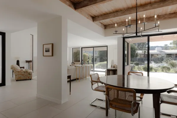 a dining room with furniture a chandelier and window
