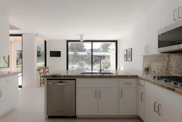 a kitchen with granite countertop a sink and a stove