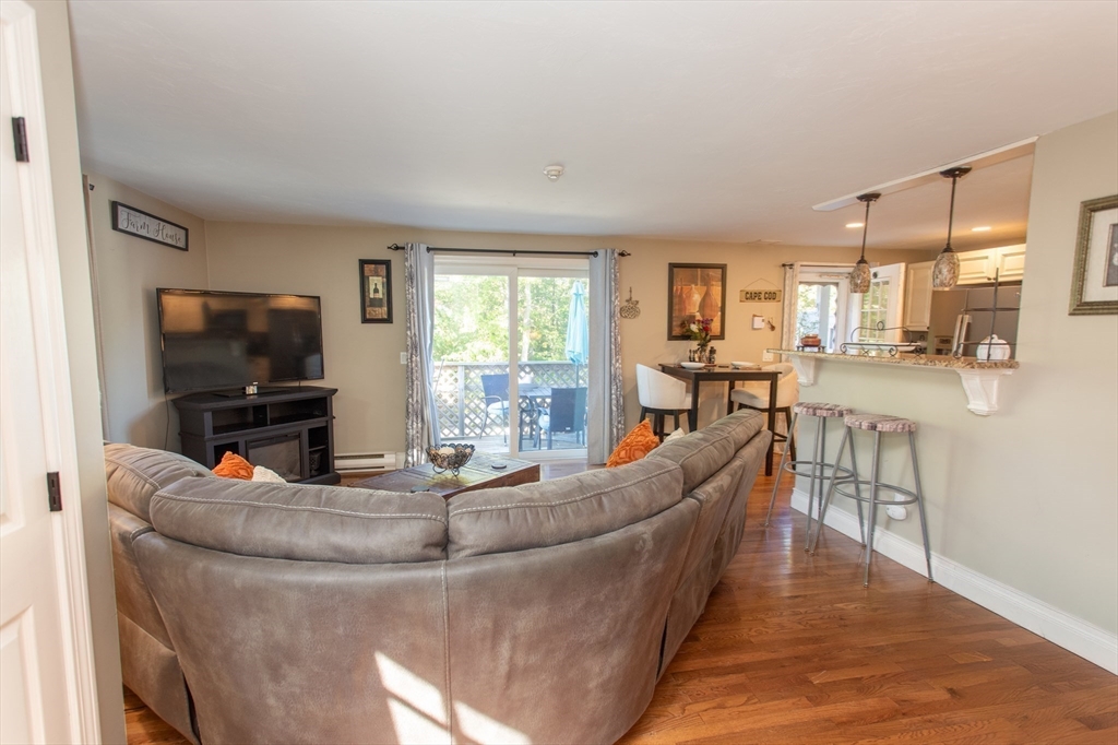11 Village Green Road, Unit B Bourne, MA 02562 - Photo 13 of 23 a living room with fireplace furniture and a flat screen tv