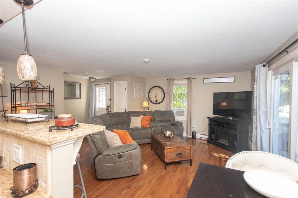 11 Village Green Road, Unit B Bourne, MA 02562 - Photo 14 of 23 a living room with fireplace furniture and a flat screen tv