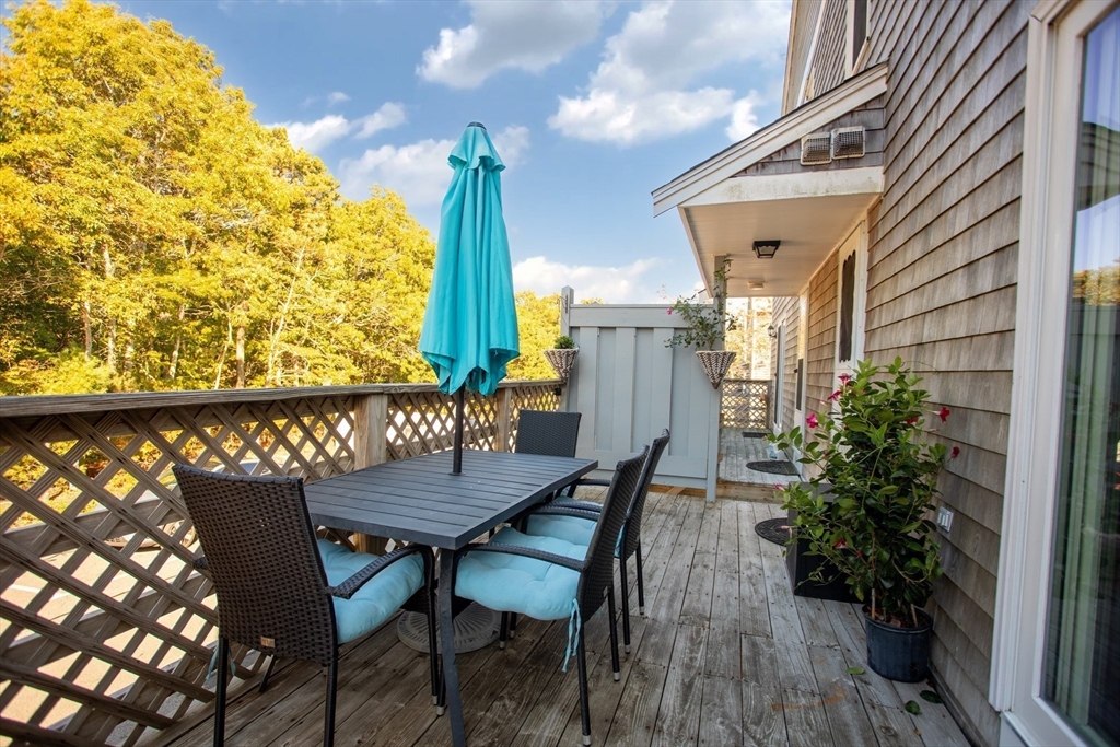 11 Village Green Road, Unit B Bourne, MA 02562 - Photo 4 of 23 a view of balcony with wooden floor and outdoor seating