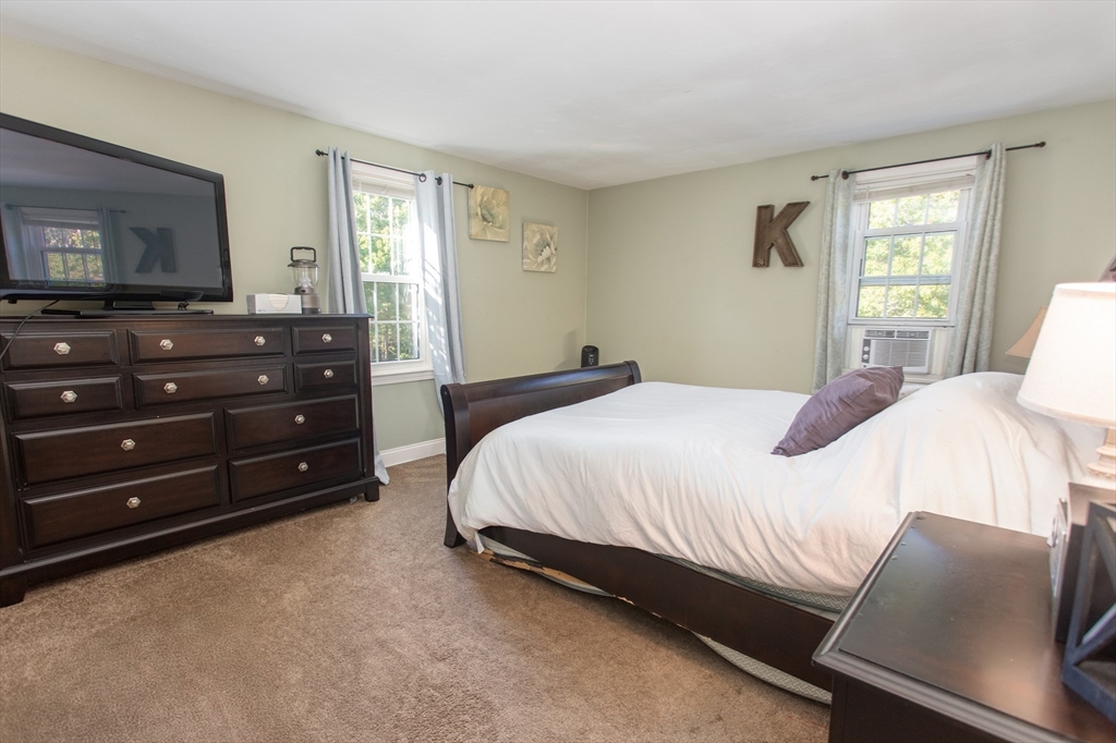 11 Village Green Road, Unit B Bourne, MA 02562 - Photo 6 of 23 a bedroom with a bed and a television