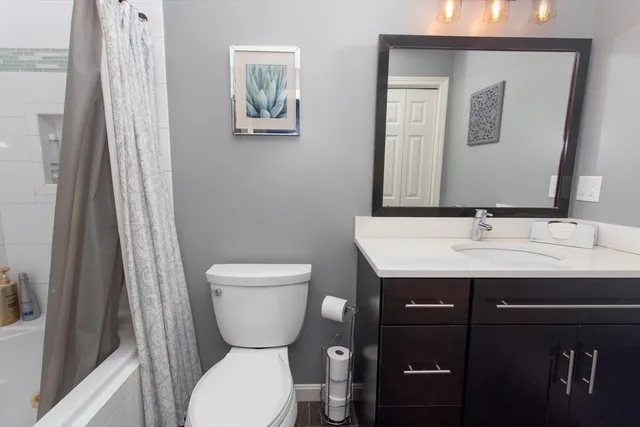 a bathroom with a toilet a sink and mirror