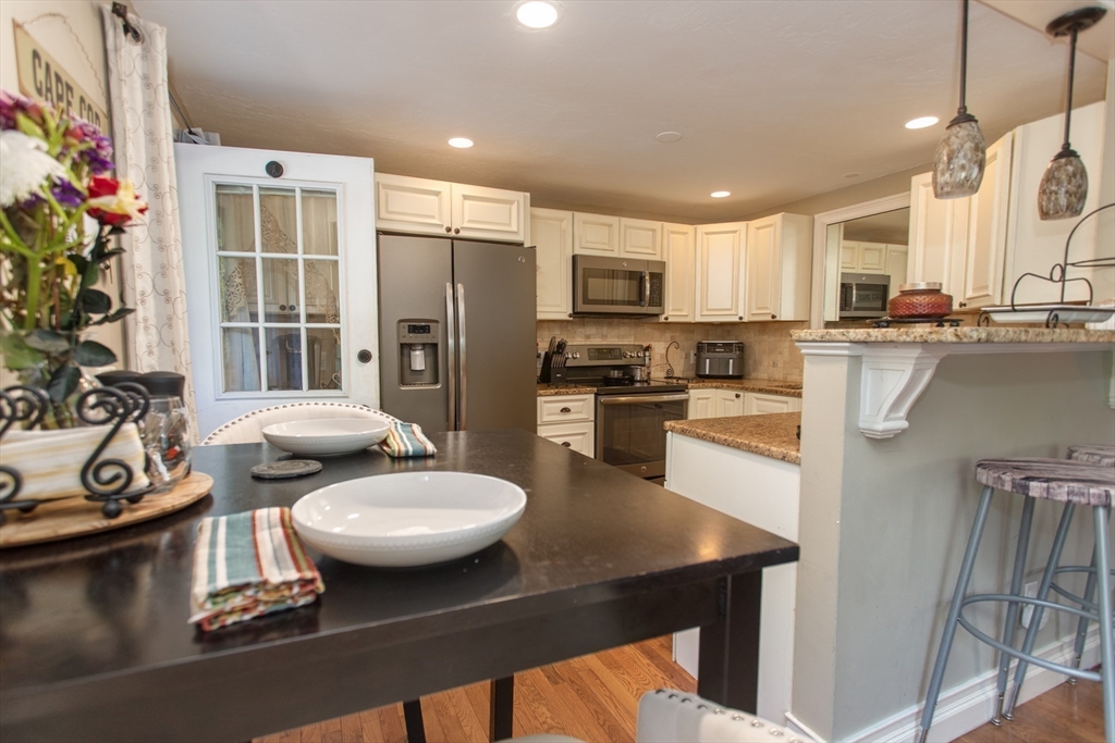11 Village Green Road, Unit B Bourne, MA 02562 - Photo 9 of 23 a kitchen with stainless steel appliances granite countertop a sink a stove and a refrigerator