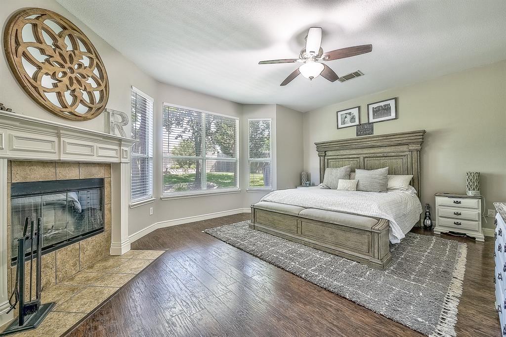 1109 Brandy Court Midlothian, TX 76065 - Photo 10 of 26 Bedroom featuring wood-type flooring, ceiling fan, and a tiled fireplace