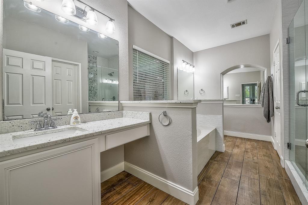 1109 Brandy Court Midlothian, TX 76065 - Photo 12 of 26 Bathroom with a garden tub, a shower stall, dark wood-style floors, vanity, and a textured wall
