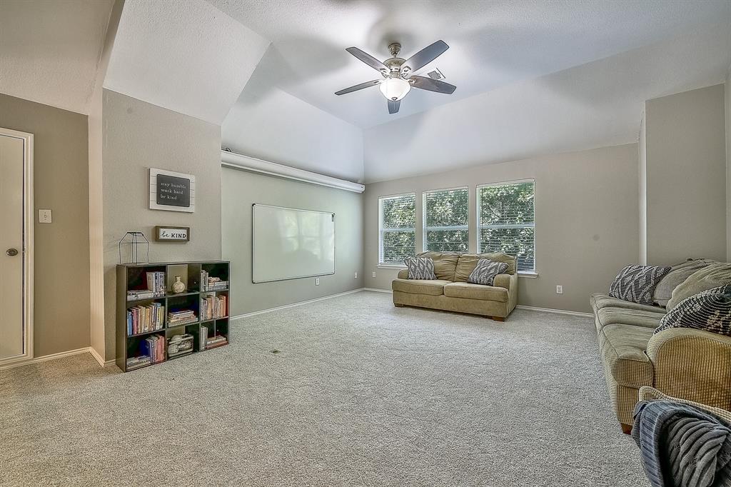 1109 Brandy Court Midlothian, TX 76065 - Photo 13 of 26 Carpeted living room featuring a ceiling fan and lofted ceiling