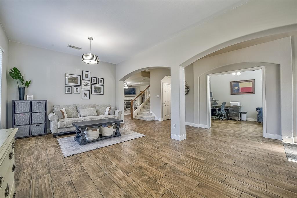 1109 Brandy Court Midlothian, TX 76065 - Photo 4 of 26 Living room with arched walkways, an office area, stairway, and light wood finished floors