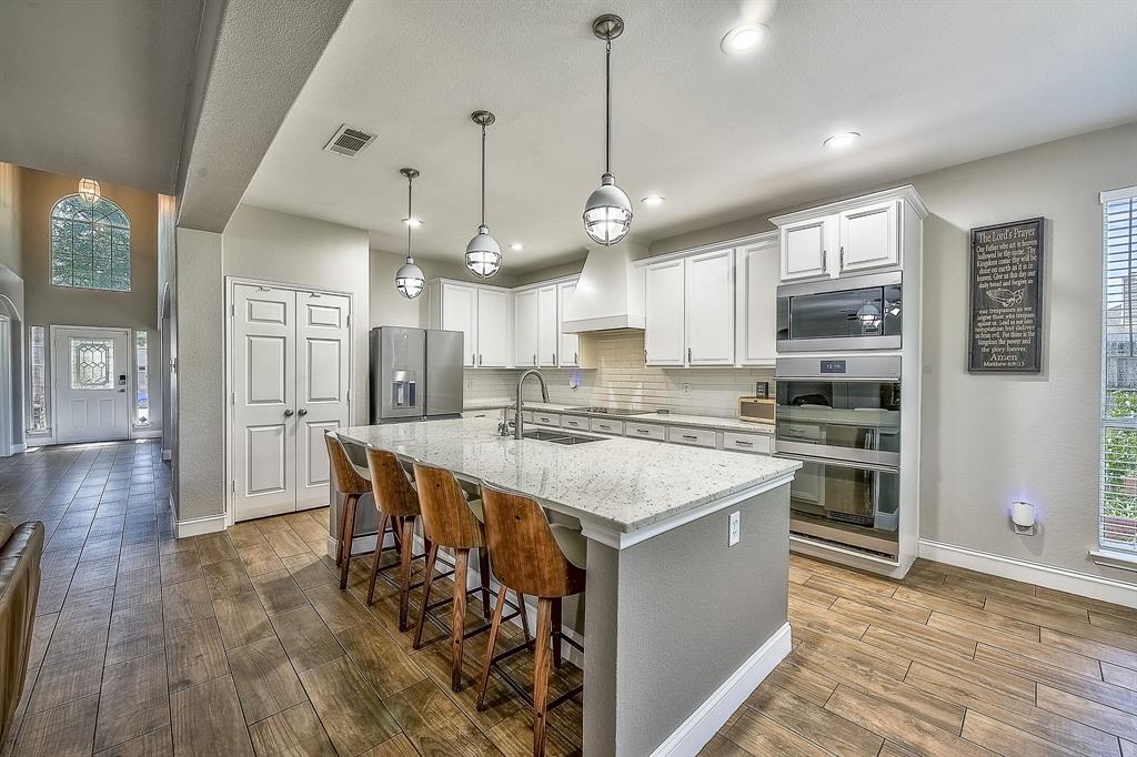 1109 Brandy Court Midlothian, TX 76065 - Photo 7 of 26 Kitchen with plenty of natural light, a kitchen breakfast bar, tasteful backsplash, stainless steel appliances, and recessed lighting