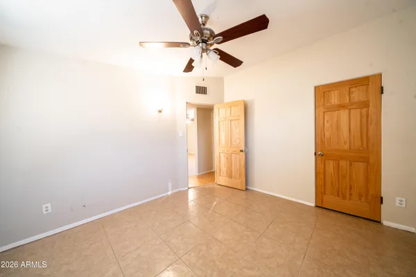 an empty room with a ceiling fan and a window