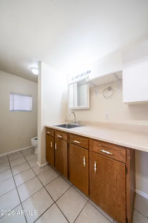 a spacious bathroom with a vanity a sink a mirror and a toilet