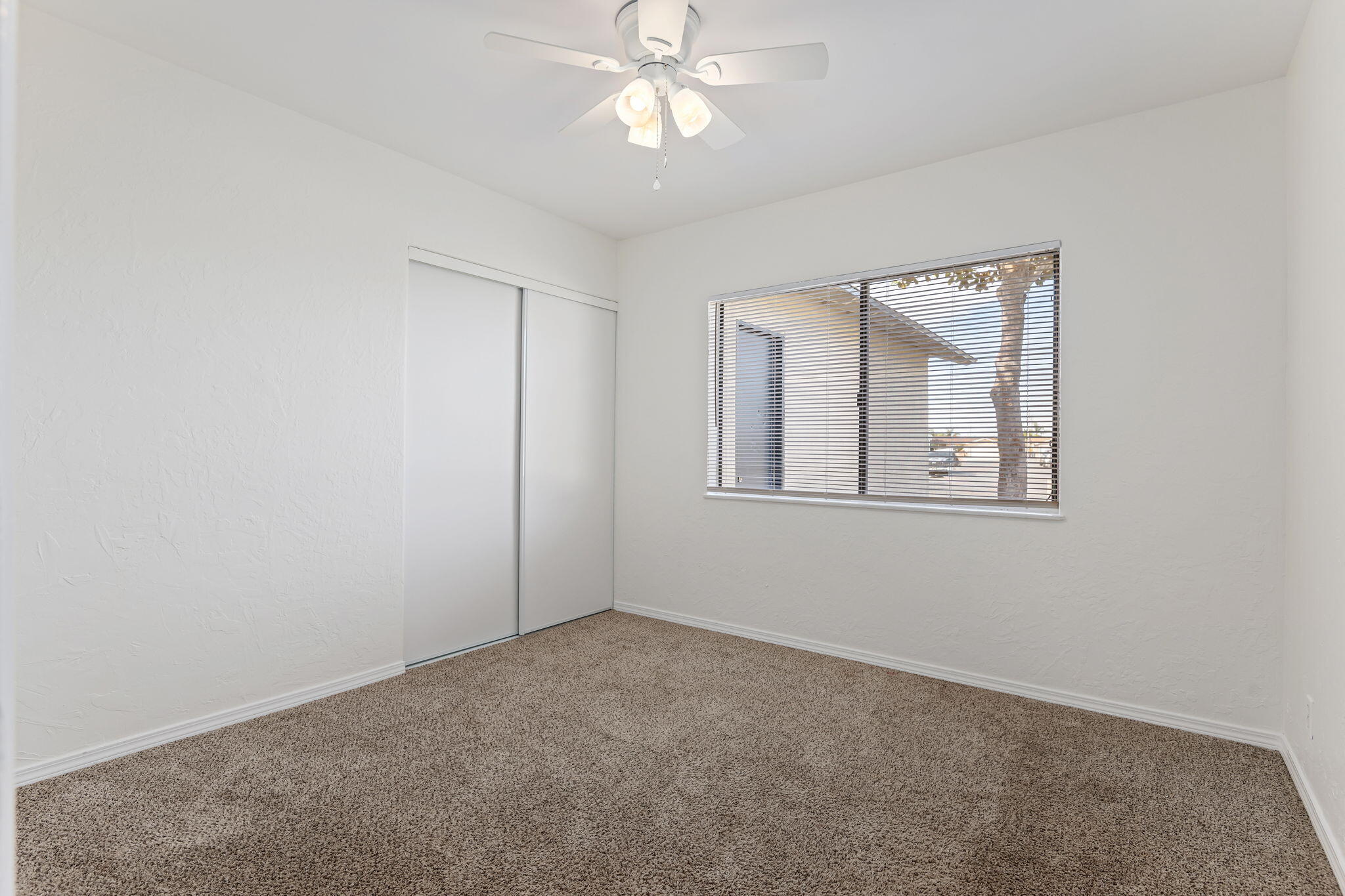 4200 South A Street Oxnard, CA 93033 - Photo 15 of 23 an empty room with a chandelier fan and windows