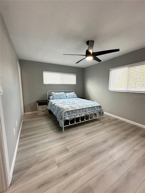 460 Base Avenue East, Unit 129 Venice, FL 34285 - Photo 12 of 33 a bedroom with a bed and a ceiling fan