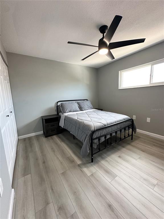 460 Base Avenue East, Unit 129 Venice, FL 34285 - Photo 18 of 33 a bedroom with a bed and a ceiling fan