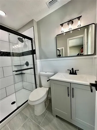 a bathroom with a sink a toilet and shower