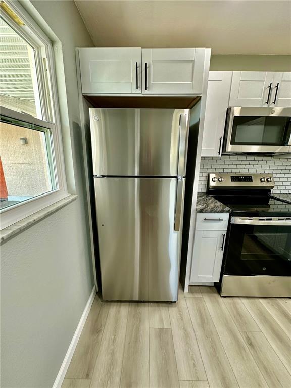 460 Base Avenue East, Unit 129 Venice, FL 34285 - Photo 4 of 33 a view of a kitchen with a refrigerator stove fridge and a window