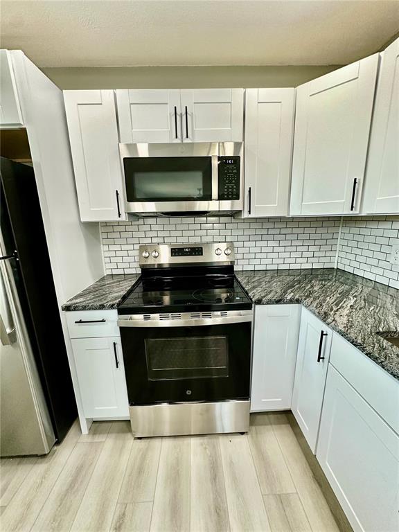 460 Base Avenue East, Unit 129 Venice, FL 34285 - Photo 5 of 33 a kitchen with stainless steel appliances granite countertop a stove a sink and a microwave