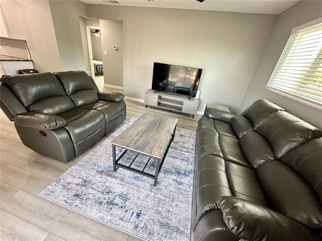 460 Base Avenue East, Unit 129 Venice, FL 34285 - Photo 7 of 33 a living room with furniture and a flat screen tv