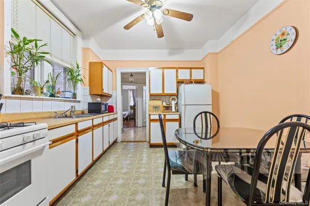 a kitchen with stainless steel appliances granite countertop a stove a refrigerator and a dining table with wooden floor