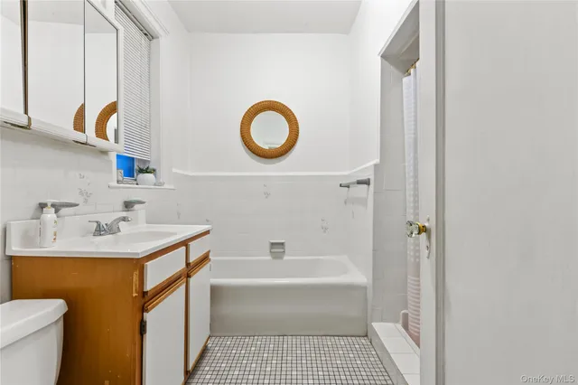 a bathroom with a sink a toilet and a mirror