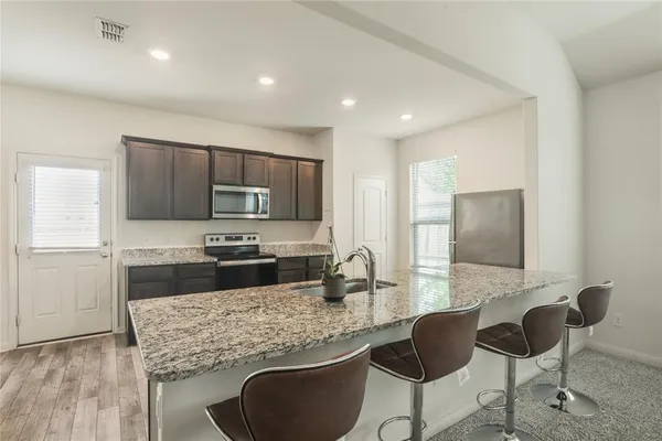 a kitchen with stainless steel appliances granite countertop a sink stove and refrigerator