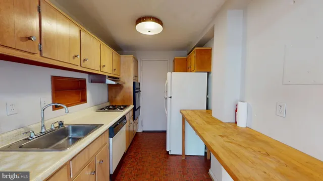a kitchen with a sink stove and wooden cabinets