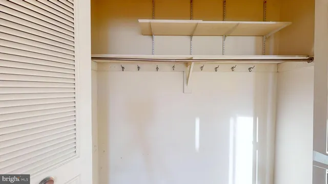 a view of a hallway with wooden floor and a bathroom