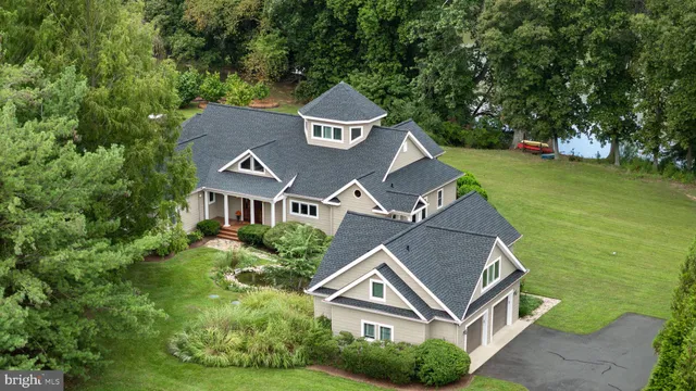 an aerial view of a house with garden space and trees all around