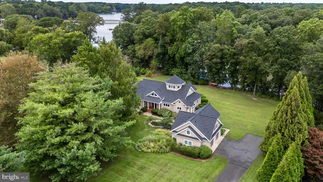 an aerial view of a house with garden space and trees all around