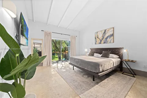 a spacious bedroom with a bed a couch and a large window