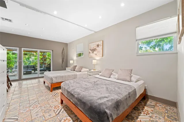 a bed sitting in a spacious bedroom next to a window